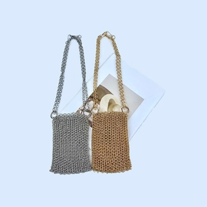 Detail showing handcrafted gold and silver metal chainmail phone bags with chain straps