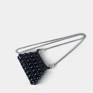 Detail of glossy black beaded mini bag with elegant silver metallic ball chain strap