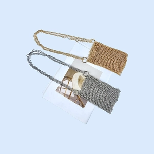 Detail of gold and silver chainmail mini bags with woven metal links and slim chain straps