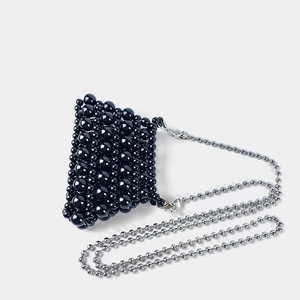 Close-up of black beaded mini bag with high-shine pearls and silver ball chain