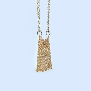 Detail of gold metal chainmail mini bag showing intricate woven mesh link texture