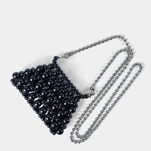 Detailed macro view of black beaded mini bag with glossy beads and silver chain strap
