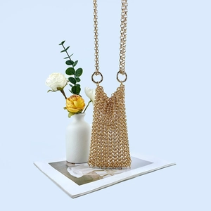Detail view of a golden chainmail crossbody bag with intricate handmade metal mesh texture
