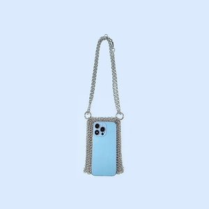Close-up of a silver handmade chainmail mini bag holding a blue smartphone inside