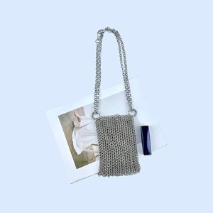 Macro shot of silver metal chainmail texture on a mini crossbody phone bag
