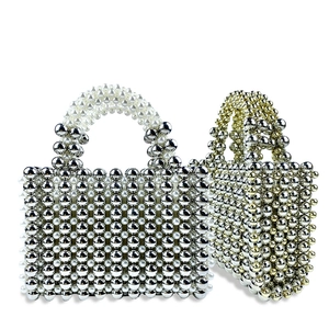 Detail of handcrafted woven bead handbag with metallic gold and pearl textures
