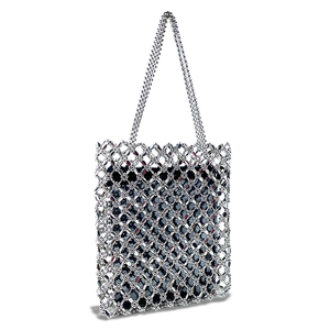 Detail of silver beaded tote bag showing hand-woven mesh structure and black inner lining