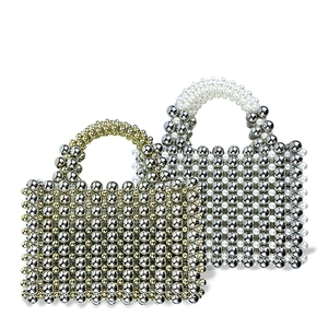 Detail of handmade beaded woven handbag showing intricate metallic and pearl bead textures