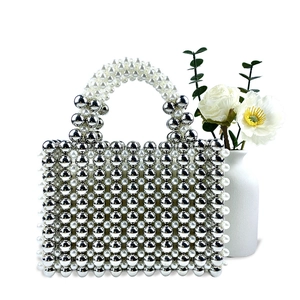 Detail of silver mirror beads and white pearls on a handcrafted woven evening handbag