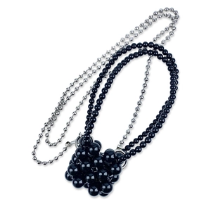 Detail van dubbellaagse kralenketting met zwarte kralen en zilveren metalen kogelketting
