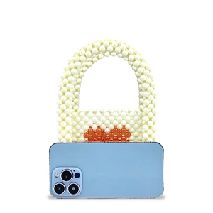 Mini handmade pearl beaded handbag with orange heart and smartphone for scale reference