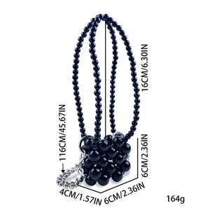 Detail van mini zwarte kralen tas met lange schouderband en metalen accenten
