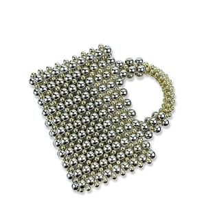 Detail of handcrafted gold and silver metallic beaded evening bag with woven hollow design