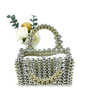 Detail of handcrafted woven bead evening bag featuring gold and silver metallic round beads