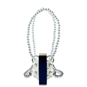 Detail van handgeweven mini-pareltas met metalen ketting en lippenstiftvakje