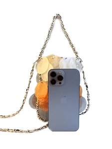Mini shell-shaped sequin crossbody bag with a slim metallic strap and phone for size reference