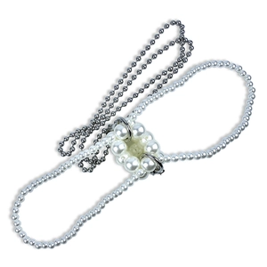 Detail van een zilveren metalen kralenketting met witte imitatieparels en een geweven ring