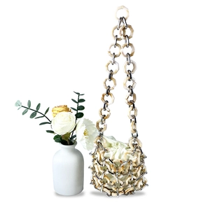 Detail der gewebten Acrylglieder und Metallringe an einer Bucket-Bag mit Satin-Innenfutter