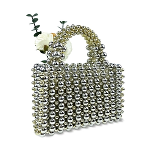 Detailed view of silver beaded evening bag with handcrafted metallic texture and rose accent