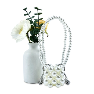 Detail van handgeweven mini-pareltas met elegante witte bloemen en parel schouderband