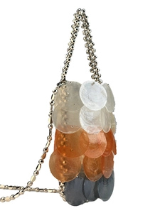 Macro shot of three-color gradient shell sequins and metal beaded strap on a handmade bag