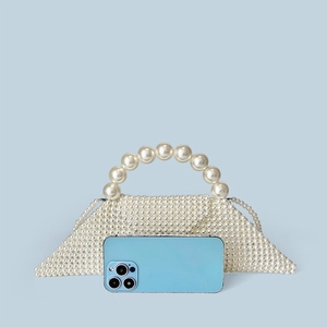 Detail of handmade white pearl beaded handbag with large round pearls on the handle