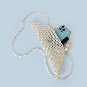 Internal capacity of handmade pearl triangle handbag showing phone and lipstick
