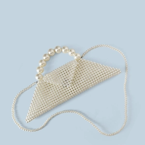 Detail of handcrafted geometric pearl handbag with beaded handle and woven texture