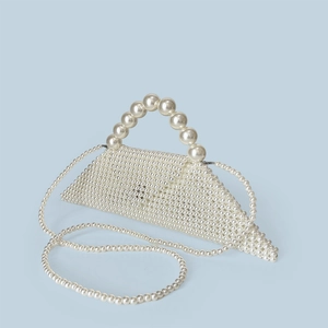 Macro shot of handcrafted pearl weave texture and unique triangular fold on a luxury bag