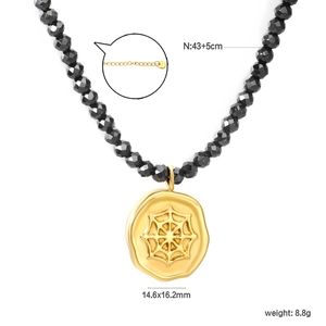 Detail of 18k gold plated spider web pendant necklace with black faceted beads chain