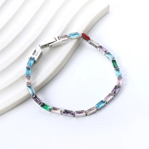 Détail d'un bracelet tennis serti de cristaux rectangulaires colorés sur métal poli