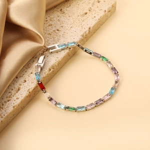 Détail d'un bracelet tennis à cristaux rectangulaires colorés sur satin et pierre