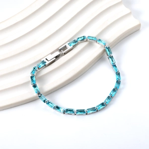 Détail du bracelet tennis bleu clair rectangulaire avec fermoir sur support ondulé
