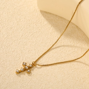 Élégant collier croix dorée avec zircons clairs sur une chaîne box minimaliste femme