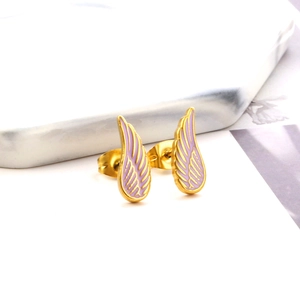Macro shot of gold angel wing stud earrings with purple enamel detailing and metal texture