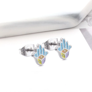 Close-up of colorful Hamsa hand stud earrings with detailed enamel inlay and symbols