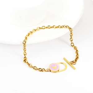 Detail eines Goldketten-Armbands mit rosa Emaille-Herzanhänger und Schmetterling