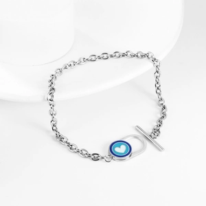 Detailaufnahme des silbernen T-Verschluss-Armbands mit Herzanhänger auf weißem Grund