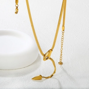 Elegant gold snake bone chain necklace with sparkling zircon pendant on white pedestal