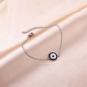 Close-up of double-chain stainless steel bracelet with crystal evil eye pendant and clasp