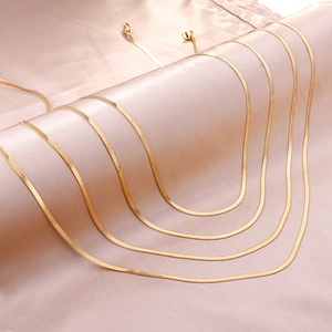 Vue détaillée du collier chaîne serpent dorée polie avec finition miroir sur du satin