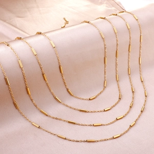 Collier chaîne croisée en acier inoxydable doré poli avec perles sur soie rose