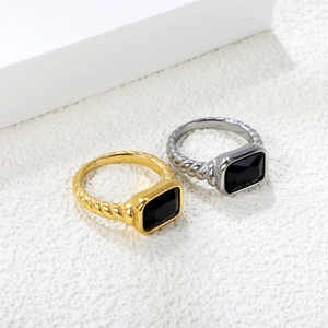 Close-up of vintage style 18K gold and silver rings with emerald cut black stone inlay