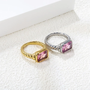 Detail of twisted rope band rings with emerald-cut pink zircon in gold and silver finish