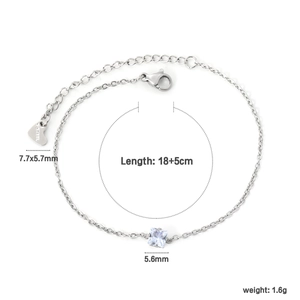 Macro detail of stainless steel bracelet featuring square zircon and heart tag pendant