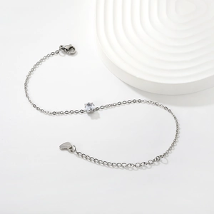 Elegant stainless steel bracelet with square cubic zirconia and heart charm on white background