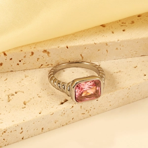 Detail shot of a rectangular pink gemstone ring with textured silver band on silk