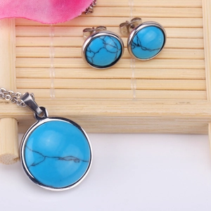 Primer plano de collar con colgante de turquesa azul y pendientes a juego en base de bambú