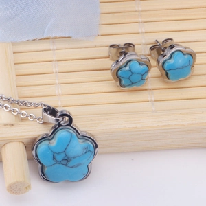 Detalle de conjunto de collar y pendientes de flor turquesa sobre una estera de bambú