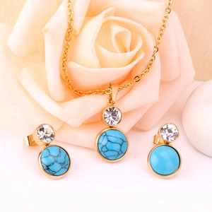 Detalle de conjunto de joyas doradas con piedras turquesas y cristales claros